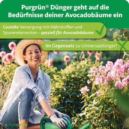 Eine lächelnde Frau mit Hut und Handschuhen kniet in einem Garten und hält eine kleine Schaufel in der Nähe von grünen Avocadobäumen und rosa Blüten. Der Text wirbt für Purgrün Bio-Avocado-Dünger 1 Liter für gesunde Avocadobäume.