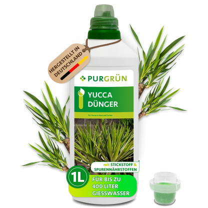 1-Liter-Flasche Purgrün Yucca-Dünger mit Dosierkappe und Anhänger „Hergestellt in Deutschland“, umgeben von Yucca-Blättern.
