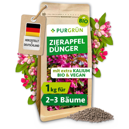 Purgrün Bio-Zierapfel-Dünger im 1-kg-Standbeutel mit sichtbarem Granulat, rosa Zierapfelblüten und Anhänger „Hergestellt in Deutschland“.