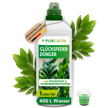 Purgrün Glücksfeder-Dünger in der 1-Liter-Flasche mit Dosierkappe, umgeben von Glücksfederblättern und dem Hinweis „Hergestellt in Deutschland“.