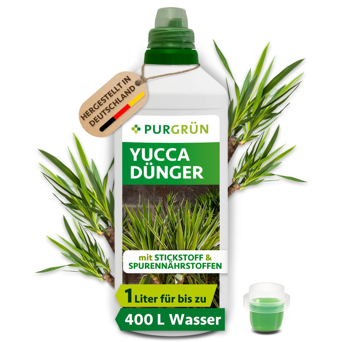 1-Liter-Flasche Purgrün Yucca-Dünger mit Dosierkappe und Anhänger „Hergestellt in Deutschland“, umgeben von Yucca-Blättern.